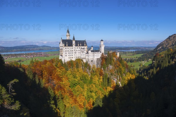 The magnificent Neuschwanstein Castle towers over an autumnal landscape with wide skies, Schwangau, Königswinkel, Ostallgäu, Allgäu, Swabia, Bavaria, Germany