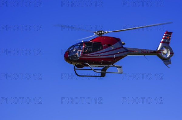 A Eurocopter EC 120B Colibri helicopter, D-HALX registration, during a flight demonstration as part of an air show on Rossfeld in Metzingen-Glems, Baden-Württemberg, Germany, for editorial use only
