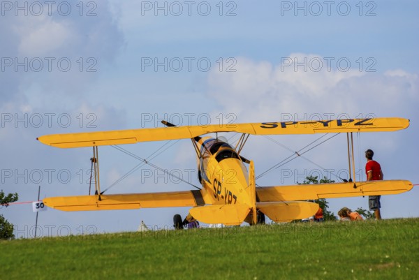A Bücker Bü 131 Jungmann biplane parked at the edge of the airfield, SP-YPZ registration, as part of an air show on Rossfeld in Metzingen-Glems, Baden-Württemberg, Germany, for editorial use only