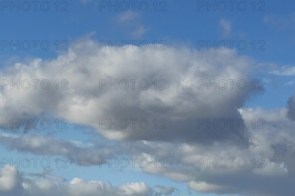 Large light gray Altocumulus Altocumulus cloud, behind more clouds under blue sky, international