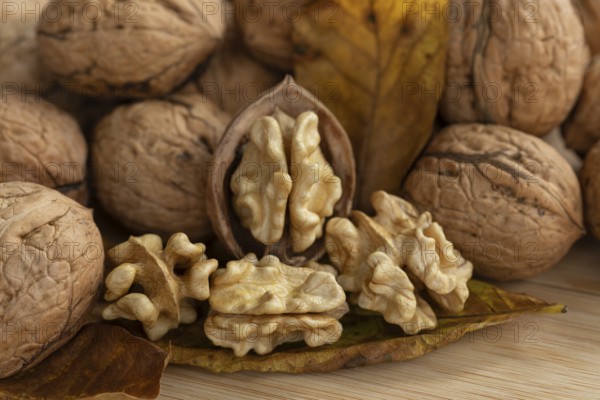 Fresh, delicious walnuts from Germany with leaves on a wooden board