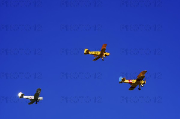 Three biplanes, a Boeing PT-17 Stearman, a Stampe-Vertongen SV-4B and a Bücker Bue 131 Jungmann fly in formation as part of an air show on Rossfeld in Metzingen-Glems, Baden-Württemberg, Germany, for editorial use only