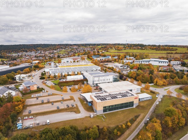 Industrial buildings and warehouses in a landscape with autumn trees and cloudy sky, Dornstetten, Freudenstadt district, Germany