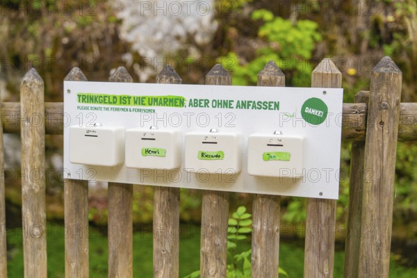 Sign on a wooden fence with a humorous message about tips, Wimsener Höhle, Hayingen, Germany