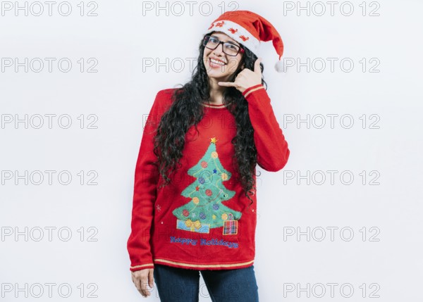 Young woman in Christmas sweater making call me gesture isolated. Beautiful girl in Christmas sweater making phone gesture