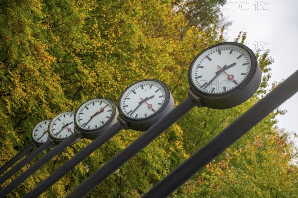 The art installation Zeitfeld in Volksgarten Park in Düsseldorf-Oberbilk, a total of 24 station clocks, on 6 meter high steel columns, have been running synchronously since 1987, artwork by Düsseldorf artist Klaus Rinke, symbol of time, time change, North Rhine-Westphalia, Germany