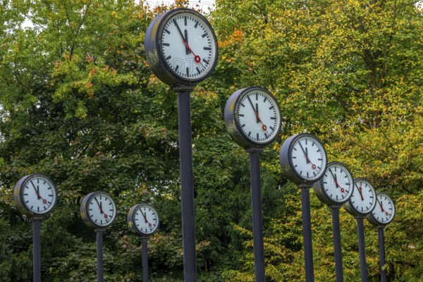 The art installation Zeitfeld in Volksgarten Park in Düsseldorf-Oberbilk, a total of 24 station clocks, on 6 meter high steel columns, have been running synchronously since 1987, dial shows five to twelve, artwork by Düsseldorf artist Klaus Rinke, symbol of time, time change, North Rhine-Westphalia, Germany