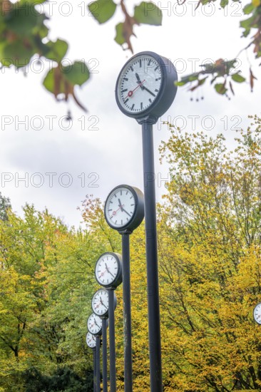 The art installation Zeitfeld in Volksgarten Park in Düsseldorf-Oberbilk, a total of 24 station clocks, on 6 meter high steel columns, have been running synchronously since 1987, artwork by Düsseldorf artist Klaus Rinke, symbol of time, time change, North Rhine-Westphalia, Germany