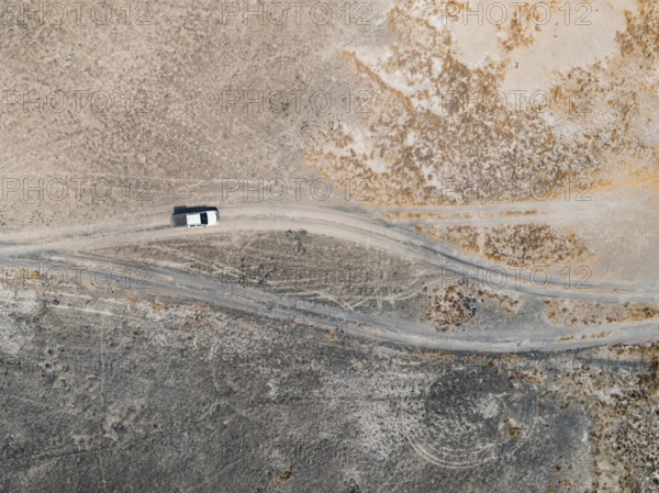Aerial view, top-down view, off-road car driving on a salt pan, arid landscape, Botswana