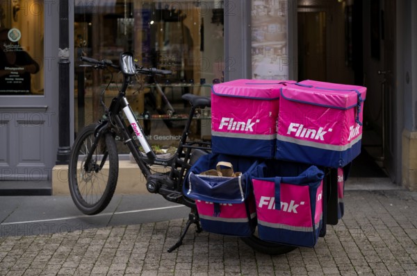 Quick, logo, delivery service, courier service, bicycle courier, e-bike stands with thermal backpack in pedestrian zone, Stuttgart, Baden-Württemberg, Germany