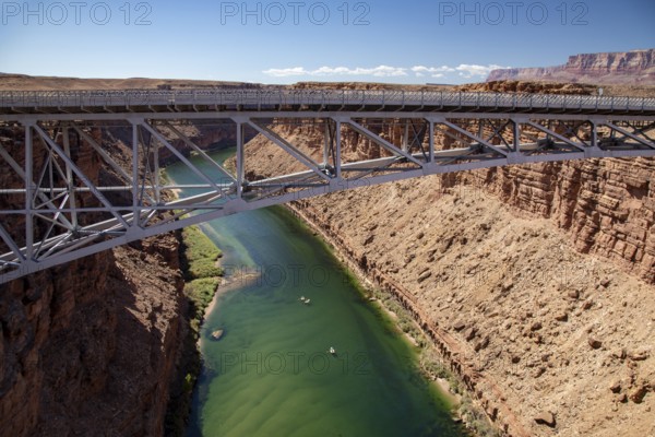 Marble Canyon, Arizona - Dories float under the Navajo Bridge which spans the Colorado River in Marble Canyon, headed towards the Grand Canyon