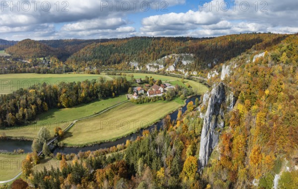Aerial view, panorama of Käppeler estate with the St. George's Basilica near Thiergarten in the upper Danube Valley, surrounded by autumn vegetation, on the right the raven rocks, climbing rocks, Jura limestone rocks, Sigmaringen district, Baden-Württemberg, Germany