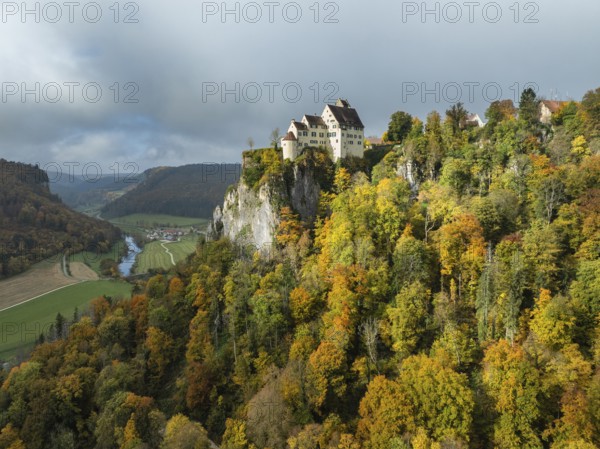 Aerial view of Werenwag Castle and former Werenwag Castle on a rocky spur in the Upper Danube Valley, surrounded by autumnal vegetation and clouds of fog, Sigmaringen district, Baden-Württemberg, Germany