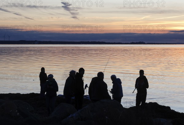 Anglers on the beach during sunset, Fehmarn Island, 18.10.2025, Fehmarn, Schleswig-Holstein, Germany