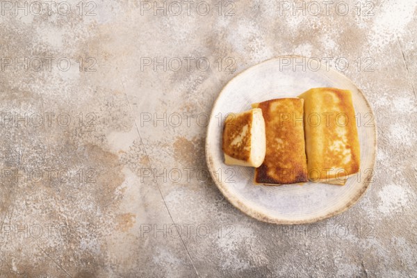 Fried crispy pancakes with meat and cheese on brown concrete background. top view, flat lay, copy space