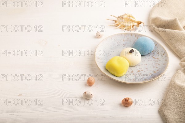 Japanese Mochi Cakes on white wooden background and linen textile, side view, copy space