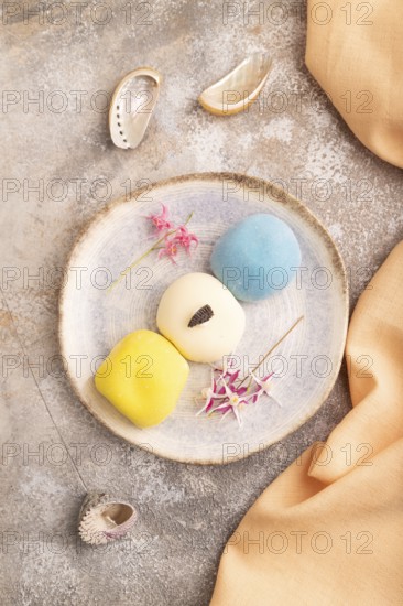 Japanese Mochi Cakes on brown concrete background and orange textile, top view, flat lay, close up