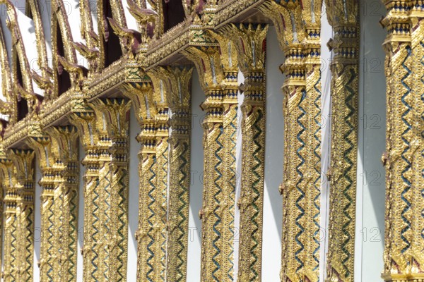 Columns with mosaic decorations (Lai Kranok), also: golden, mosaic-decorated Thai temple columns (Sao), decorated in Lai Kranok style, typical of Rattanakosin architecture (Bangkok style), on the outer façade of the Ubosot (ordination hall), Wat Chana Songkhram, Phra Nakhon, Bangkok, Thailand