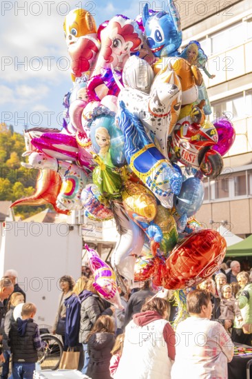 Colourful balloons in the form of cartoon characters float above a crowd at a festival, Urschelherbst street festival, Nagold, Germany