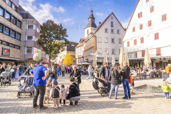 Bustling market square with families, church in the background, sunny day and historic houses, Urschelherbst street festival, Nagold, Germany