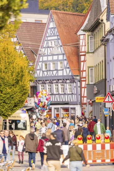 Street festival in the old town with half-timbered houses, people and colorful balloons in autumn, Urschelherbst street festival, Nagold, Germany