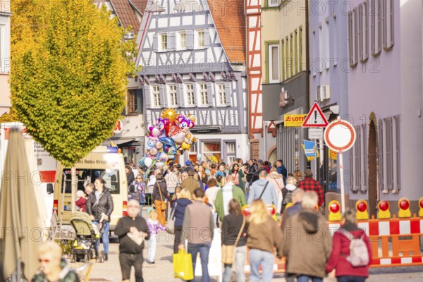 View of a busy street with half-timbered houses, construction site and crowd in the city, Urschelherbst street festival, Nagold, Germany