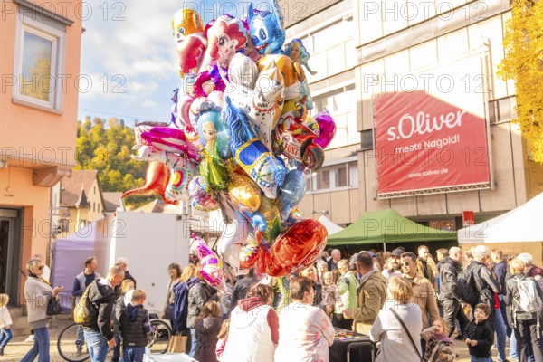 Large collection of colorful balloons above a crowd in sunny autumn weather, Urschelherbst street festival, Nagold, Germany
