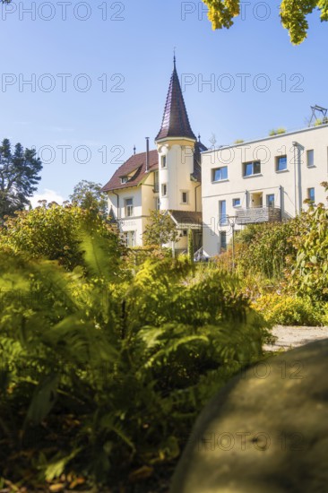 Manor house with pointed roof between thick vegetation and clear blue sky, Überlingen, Lake Constance, Germany