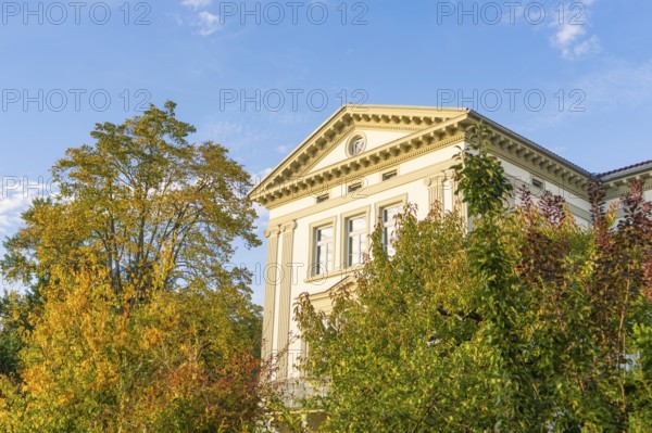 Elegant historic building surrounded by autumn trees under blue sky, Überlingen, Lake Constance, Germany