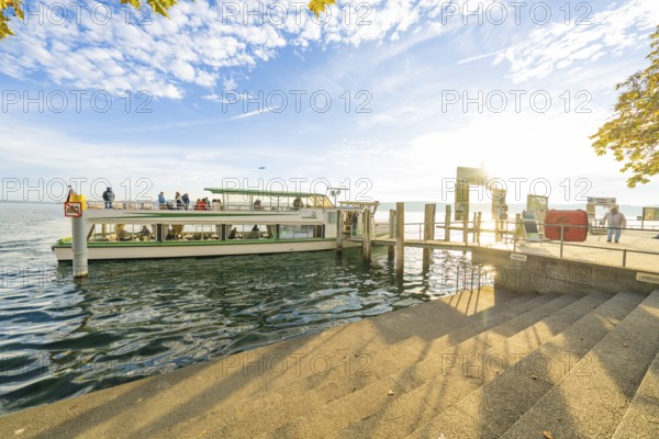 A boat is moored on a jetty in sunny weather, surrounded by calm water, Überlingen, Lake Constance, Germany