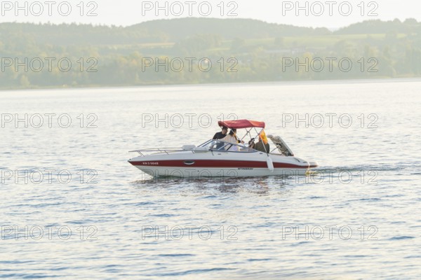 A motorboat with people enjoying a relaxing trip on a quiet lake, Überlingen, Lake Constance, Germany
