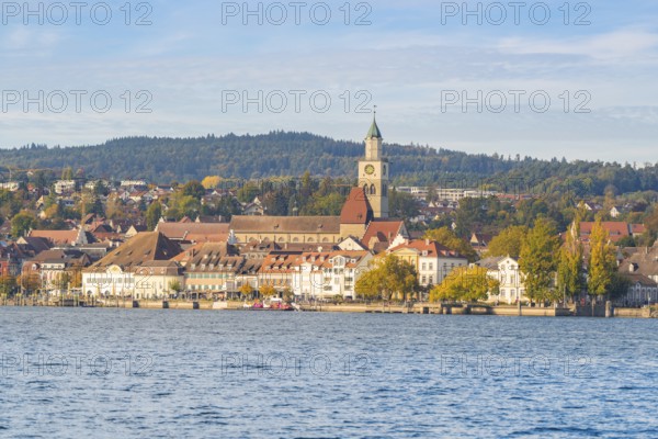 Lakeside city view with church tower, colorful trees and wooded hills, Überlingen, Lake Constance, Germany