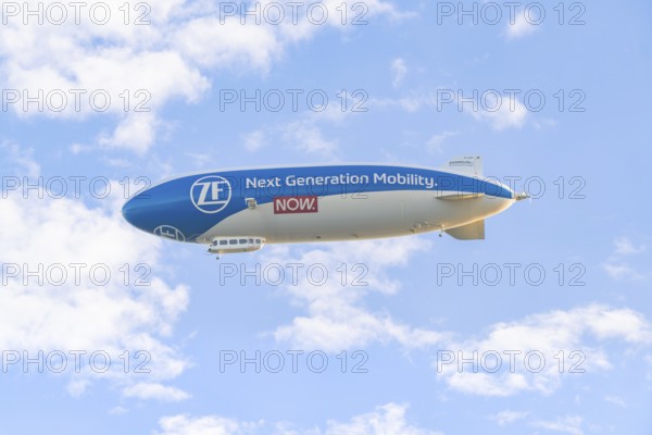 Zeppelin advertising new mobility in a blue sky with clouds, Überlingen, Lake Constance, Germany