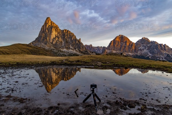 Reflection of the Ra Gusela and Tofane mountains at sunrise, in front a tripod with camera in the mud, Passo di Giau, Giau Pass, Dolomites, Alps, Belluno province, Veneto, Italy