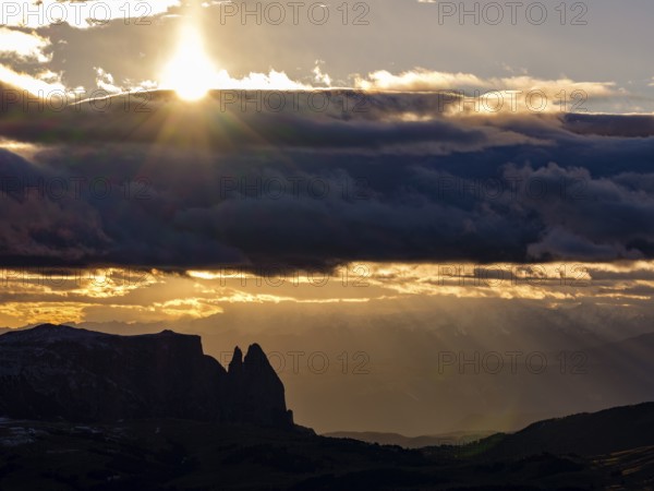 View of the Sciliar under dark clouds with sun, Dolomites, Trentino, South Tyrol, Italy
