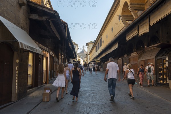 Ponte Vecchio, jewelry stores, dome of Santa Maria del Fiore Cathedral in the background, Florence, Tuscany, Italy