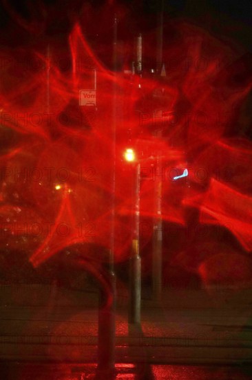 Traffic light, road traffic at night and poor visibility in a city, autumn, Germany
