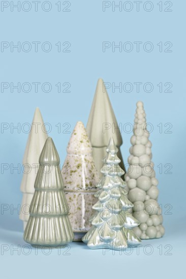 Beautiful different shaped light green ceramic Christmas trees on blue background