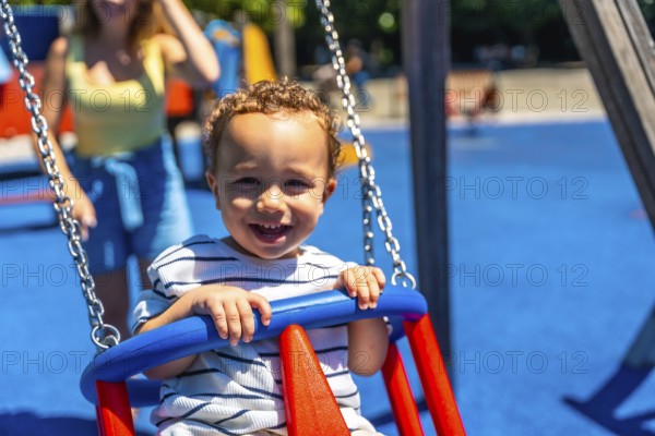 Happy toddler smiles while enjoying a swing ride at the playground, creating a joyful childhood scene