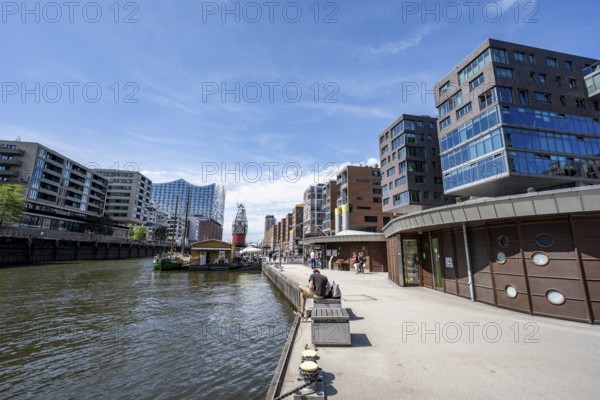 Modern residential buildings, pier at the traditional ship harbor on Sandtorkai, behind Elbphilharmonie, HafenCity, Hamburg, Germany
