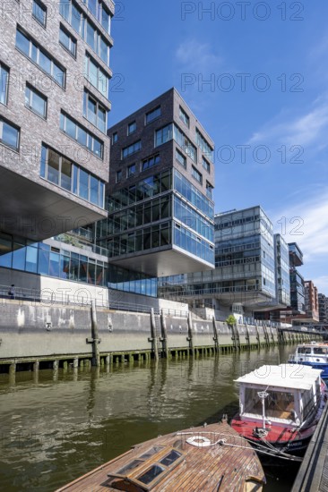 Modern residential buildings, boats at the traditional shipping harbor on Sandtorkai, behind Elbphilharmonie, HafenCity, Hamburg, Germany