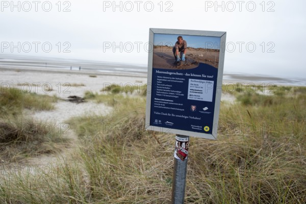 A sign on the beach on the island of Föhr provides information about marine mammal protection in the Wadden Sea National Park, Schleswig Holstein, Germany