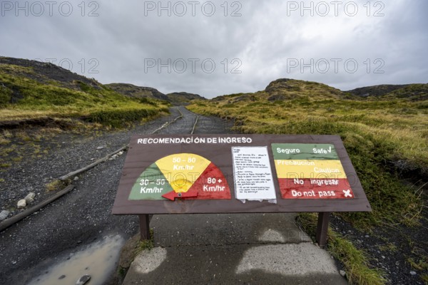 Warning sign for strong winds, gusts of wind on a hiking trail, Torres del Paine, Chile