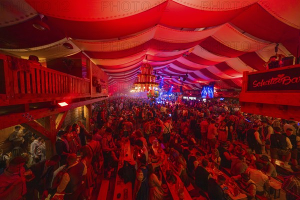 Full beer tent with people, red ceiling and stage, lively and festive atmosphere, Volksfest Cannstatter Wasen, Sonja Merz Festzelt, Stuttgart, Germany