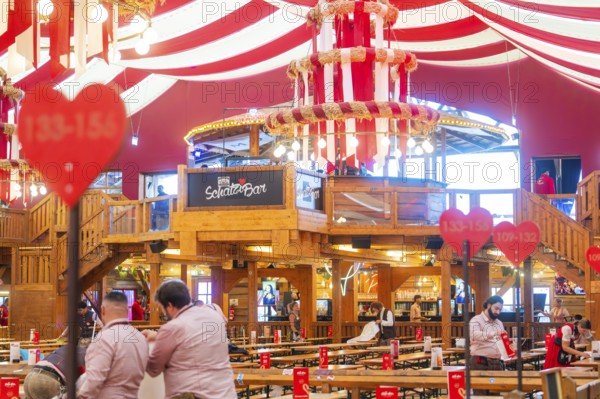 Interior view of a festively decorated beer tent with heart decorations and a bar in the centre, Volksfest Cannstatter Wasen, Sonja Merz Festzelt, Stuttgart, Germany