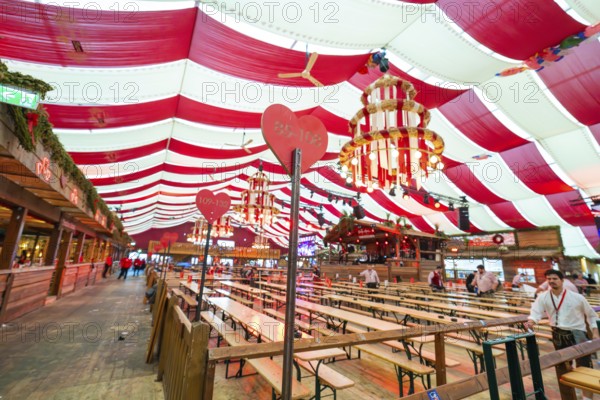 Cosy beer tent with red blankets, wooden benches and hearts as decoration, Volksfest Cannstatter Wasen, Sonja Merz Festzelt, Stuttgart, Germany