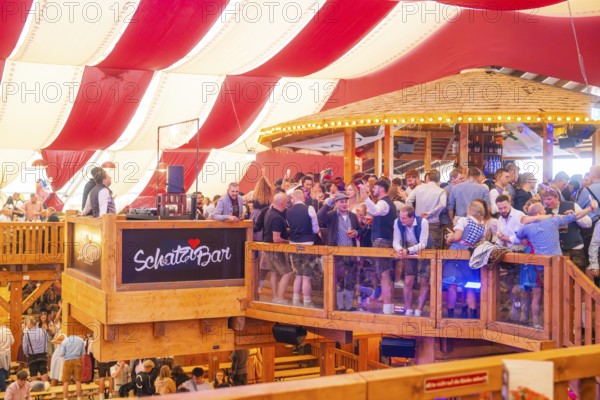 A crowded upper bar with people in traditional dress in a festively decorated room, Volksfest Cannstatter Wasen, Sonja Merz Festzelt, Stuttgart, Germany