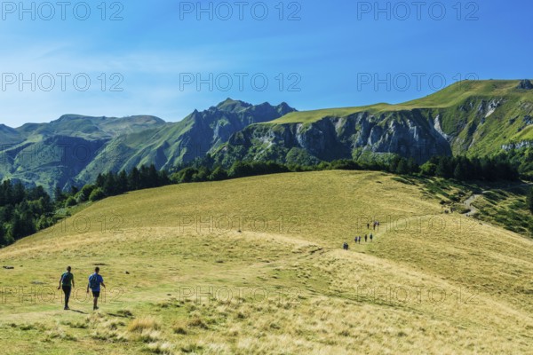 Auvergne Volcanoes Regional Park. Groups of hikers traverse a rugged path in the beautiful Sancy Massif region, Puy de Dome, Auvergne, France