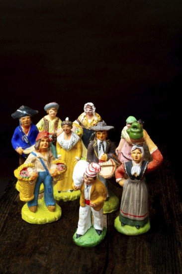 Colorful Provençal terracotta figurines represent traditional characters from rural life. Each figure is uniquely crafted, depicting musicians, farmers, and market sellers in detailed attire