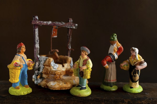 Colorful Provençal terracotta Santons figurines showcase characters engaged in various activities, featuring artisans, farmers, and market sellers